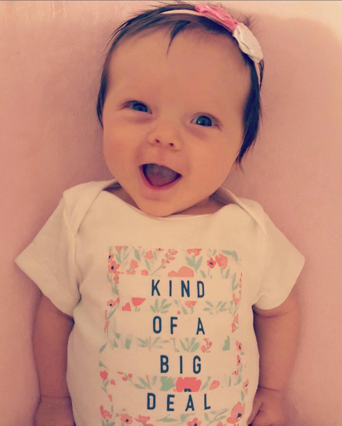 Smiling baby wearing a Kind of a Big Deal onesie at Kind Kids